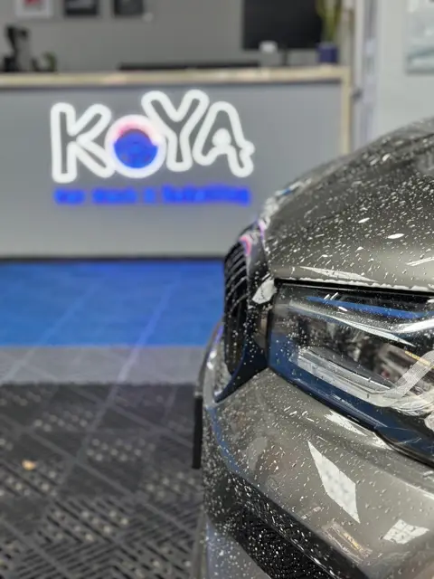 Snow foam on BMW headlamp in front of KOYA counter