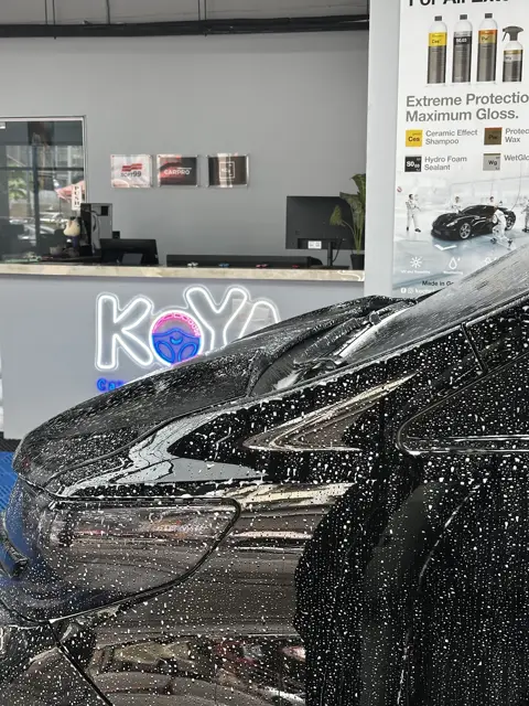 Snow foam on a dark car beside the KOYA counter